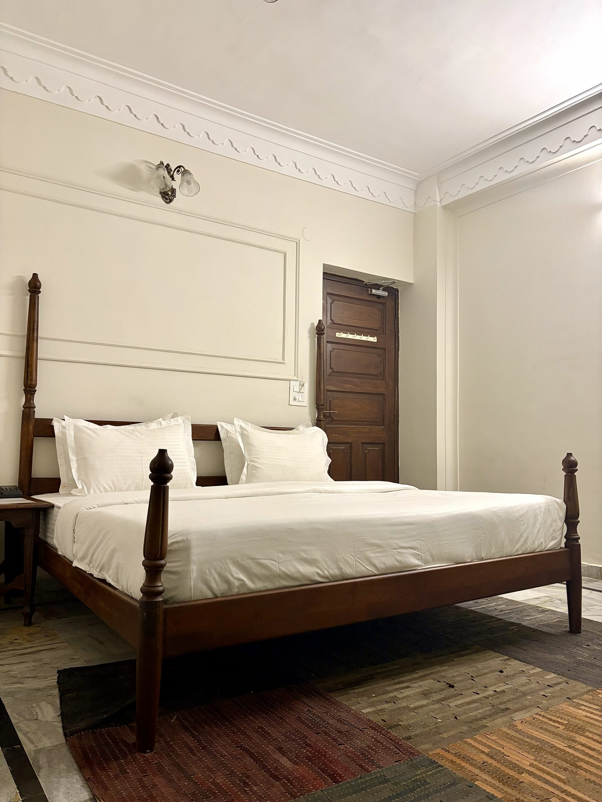 Super Deluxe Room at Hotel Royale Plazo Jodhpur with large wooden bed, clean white bedding, bright lighting and classic interior design