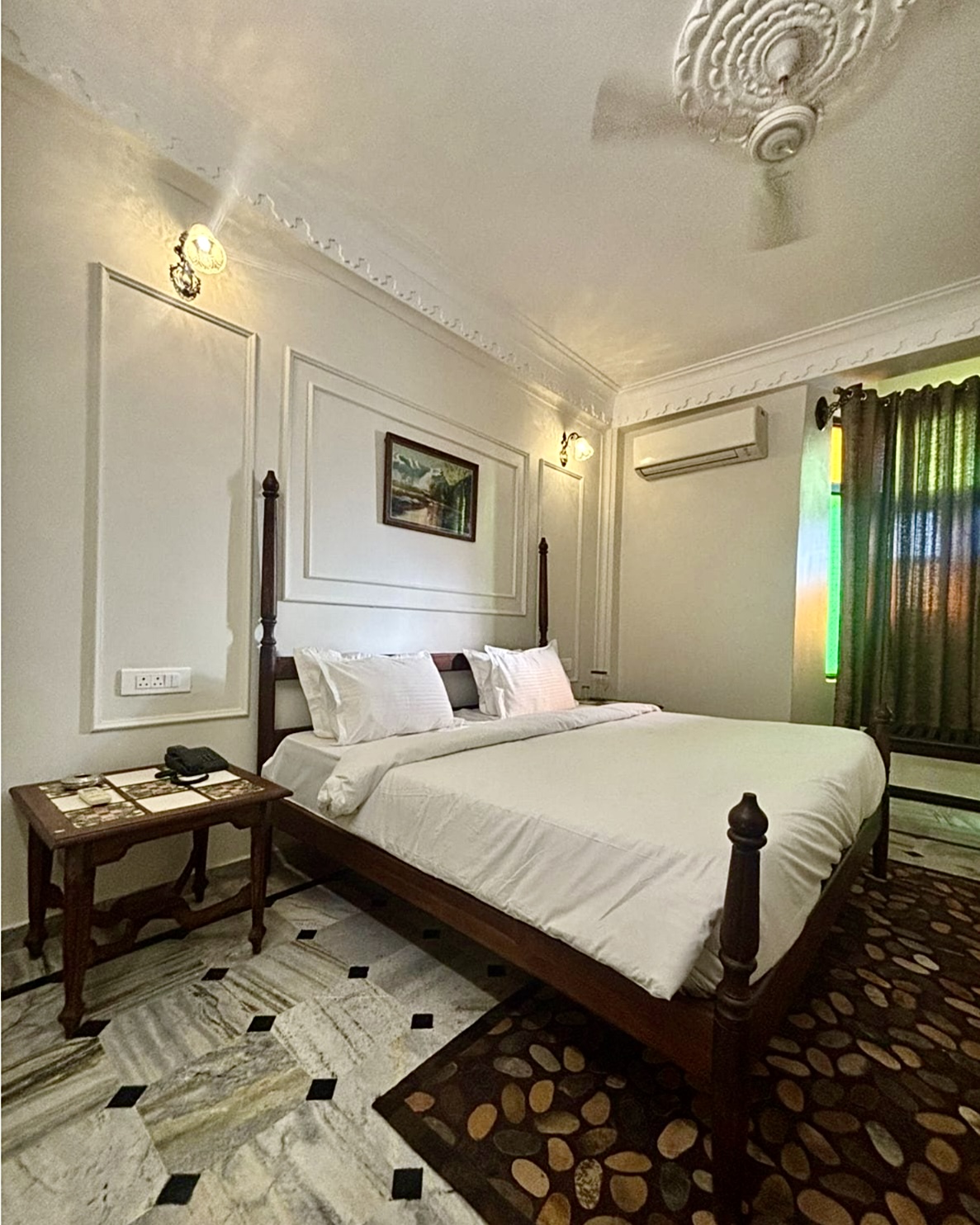 Executive Room at Hotel Royale Plazo Jodhpur with large wooden bed, premium white bedding, artistic ceiling design, warm lighting, and marble flooring